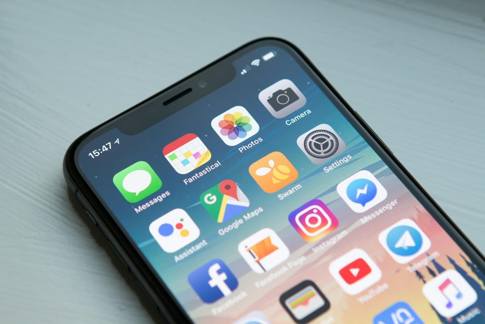 Smartphone showing a grid of mobile apps on a desk